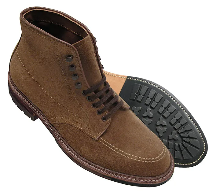 The Alden Madison 4011HC - Indy Boot features snuff suede lace-up design, black rubber soles, and a durable storm welt. One boot stands upright while the other lies on its side, highlighting the tread pattern. They have brown stitching and six eyelets for 