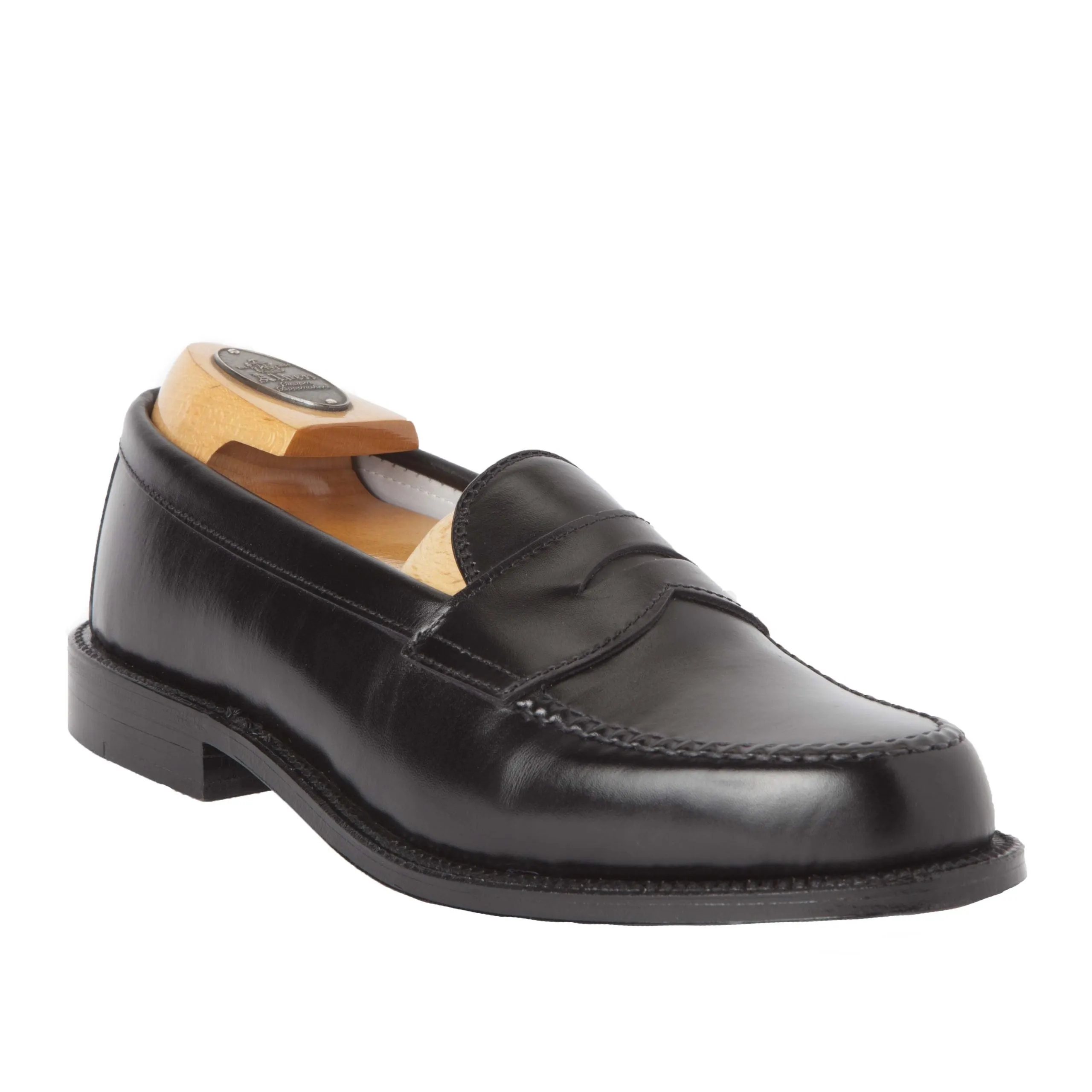 The Alden Madison 981 - Leisure Hand Sewn in Black Calfskin is a sleek moc toe loafer with stitching details, featuring a leather outsole and an included wooden shoe tree for structure and shape maintenance.