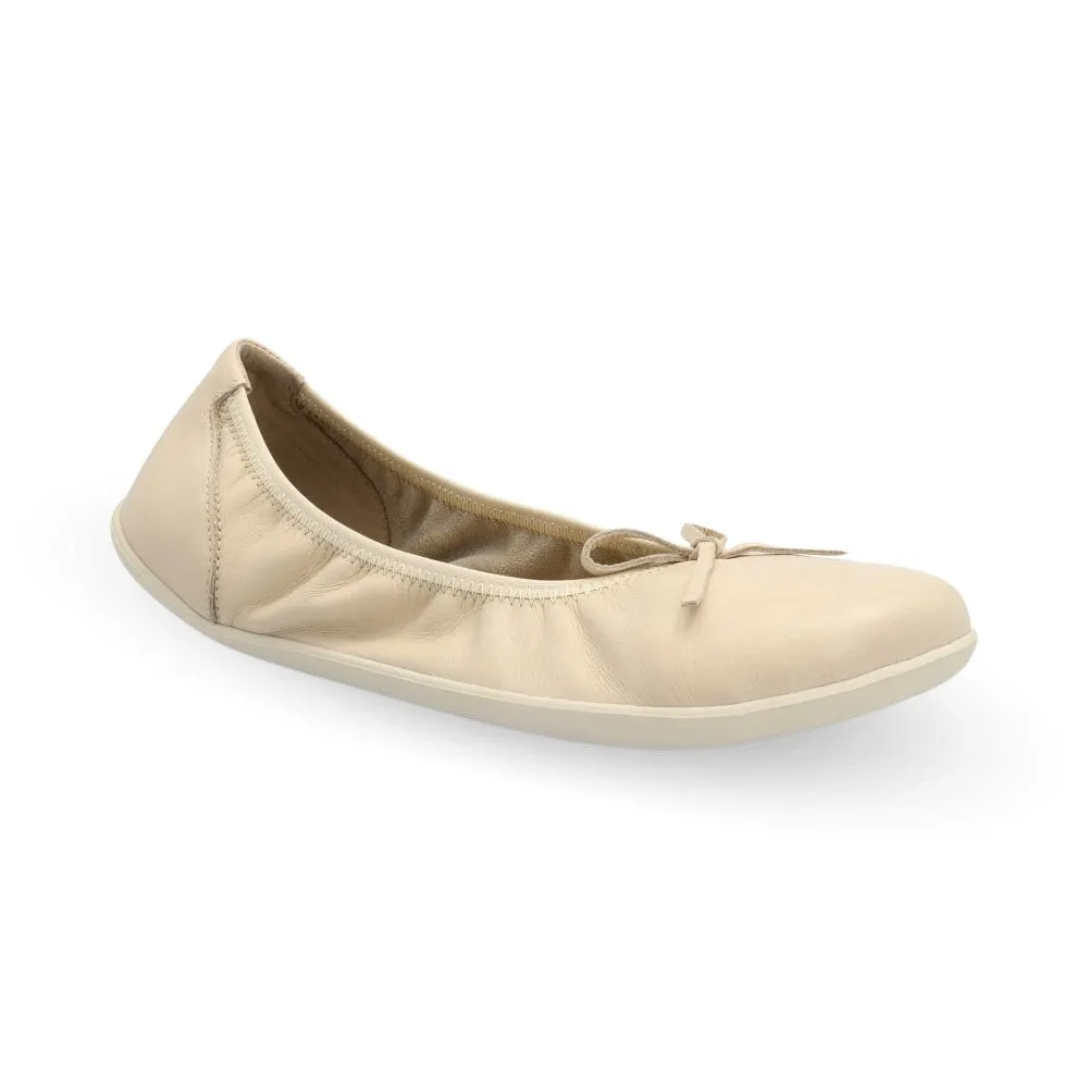 Nude Groundies Ruby leather ballet flat. Shoes are light beige all around with a leather bow and elastic around the opening. Right shoe is shown here facing diagonally right against a white background. #color_nude
