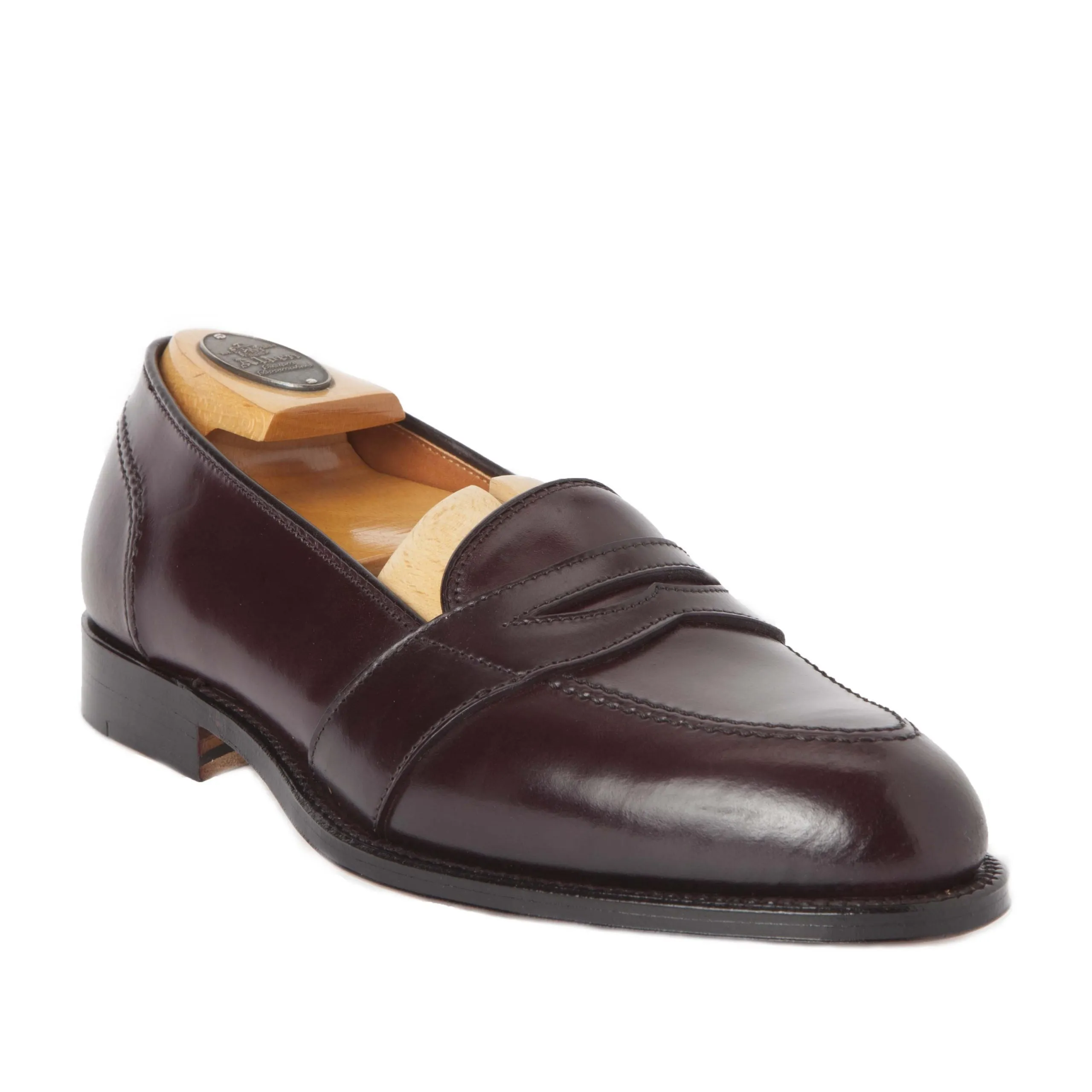 The Alden Madison 684 Full Strap Loafer in Color 8 Shell is showcased with a dark brown polished finish, low heel, and classic penny strap. A wooden shoe tree inside highlights its refined craftsmanship and timeless appeal.