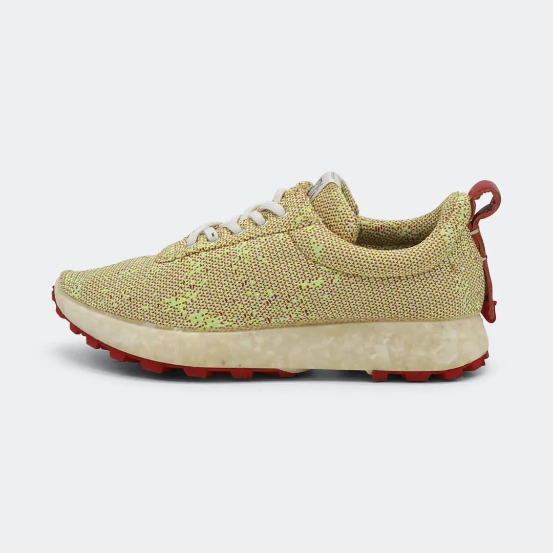 Sneakers with a yellow and pink print, featuring a textured upper and a white sole with red accents lateral view