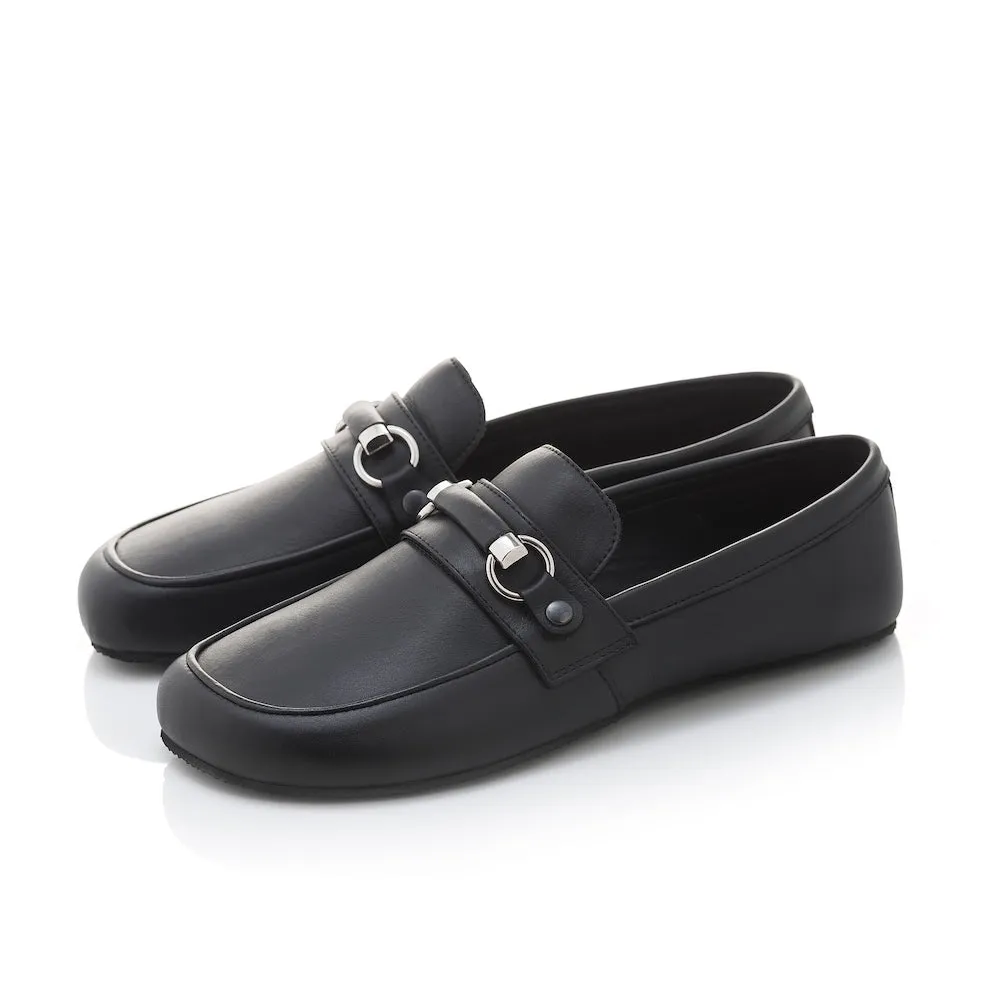 Black leather Shapen Versa loafers. Shoes are a classic loafer design with a leather decoration capped by silver metal rings across the foot and black rubber soles glued on. Both shoes are shown facing diagonally left against a white background. #color_bla